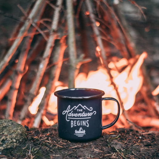The Adventure Begins mug in front of a bonfire - photo by Ole Witt