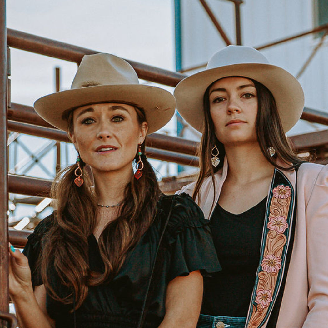 Two long haired models wearing earrings with natural aspen leaves by Buckaroo Bling