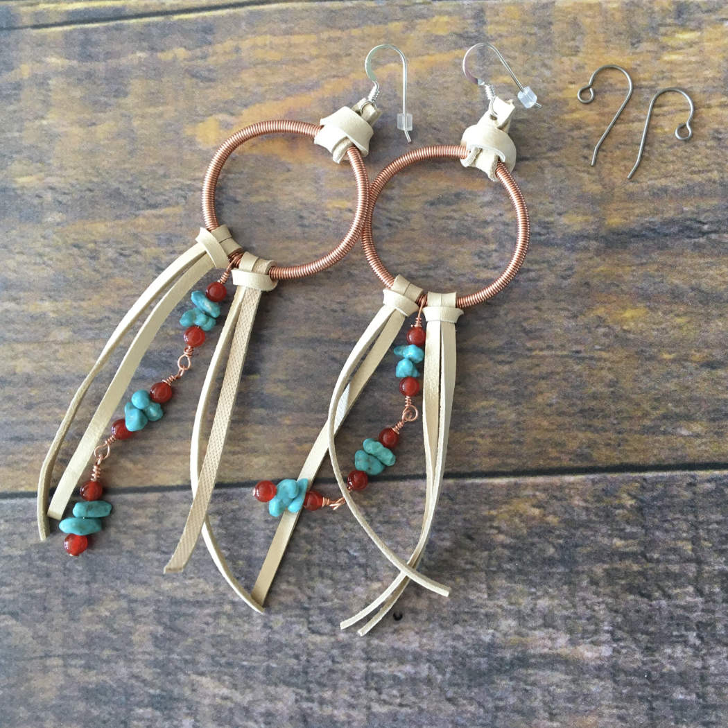 A pair of titanium ear wires next to a pair of leather fringe earrings with sterlin silver ear wires